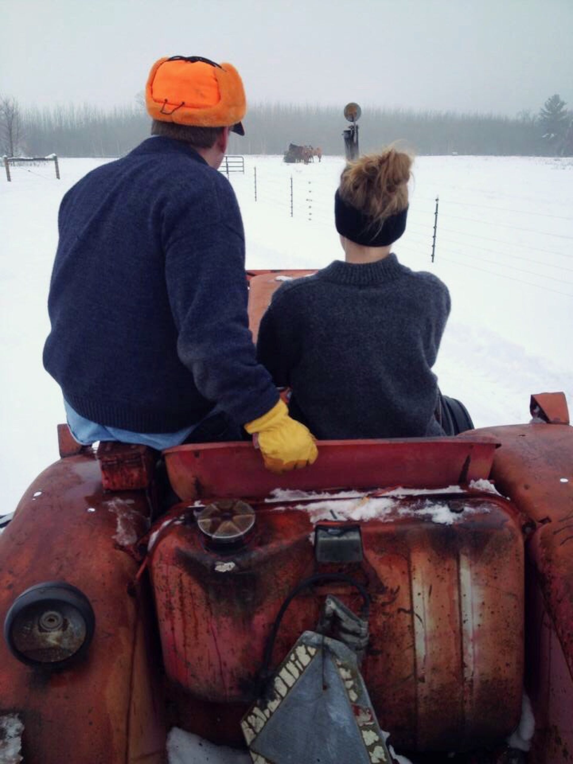 Molly Brown and her father driving a tractor through a snow-covered field