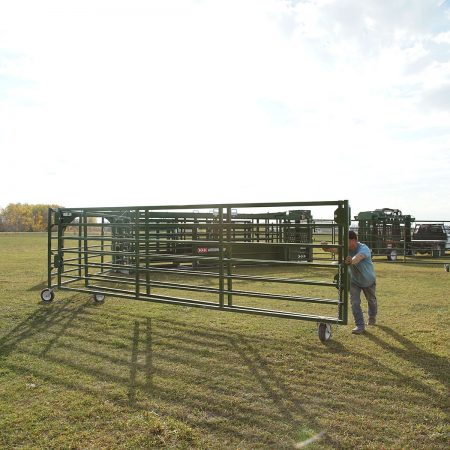 Rancher setting up the portable corral system by swinging the corral panels out and into place