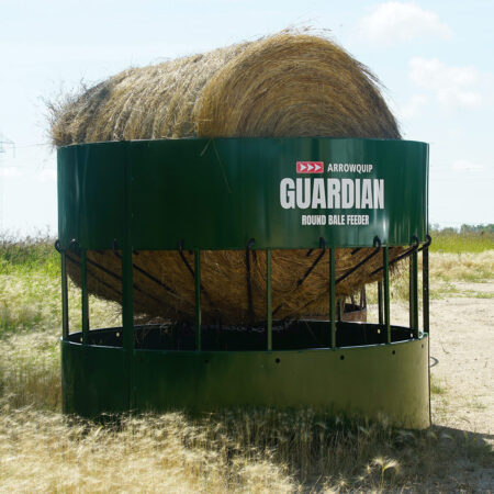 Round bale feeder with hay in pasture