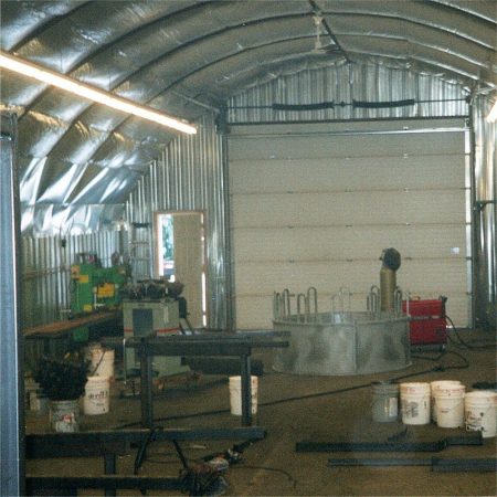 Early Arrowquip cattle equipment manufacturing taking place in hog barn